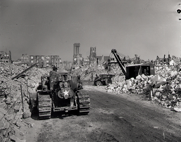 Clearing, by the Royal Canadian Engineers, of rubble in order to start an other road to the river bridges, Caen, Normandy, 4 August 1944. Photo by Ken Bell. Department of National Defence / National Archives of Canada, PA-169342.